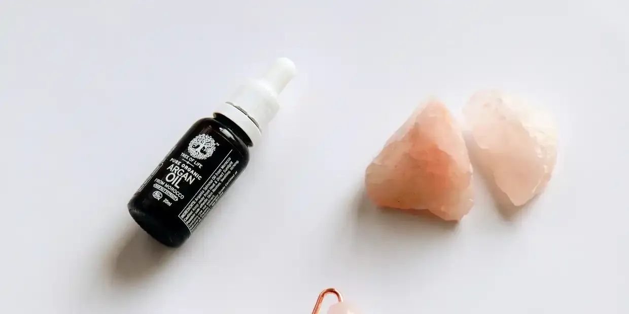 Rose quartz and jade gua sha tools on a marble surface