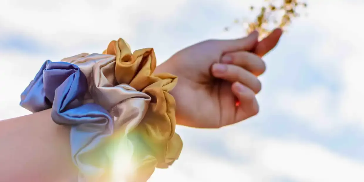 A collection of silk and satin scrunchies in soft colors